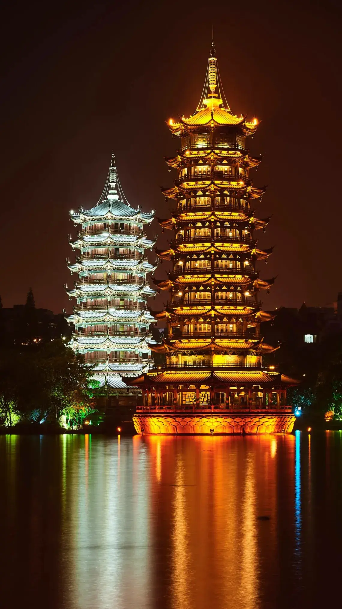 Las Torres del Sol y la Luna de Guilin iluminadas y reflejadas en el lago al anochecer